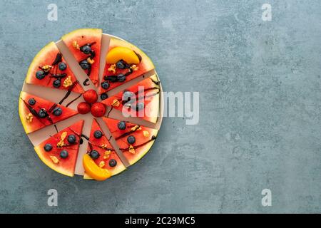 Colorful juicy watermelon pizza topped with berries, nuts, and chocolate sauce. Stock Photo