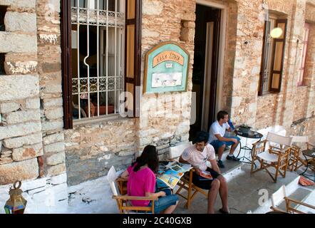 Symi / Greece / August 14 2009 : A cafe in the upper town.  Relaxed tourists enjoy a drink in a bar in a converted old fashioned town house. Stock Photo