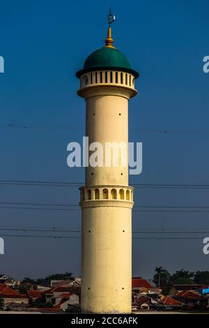 The mosque's green domed minaret is isolated by the blue sky. Stock Photo