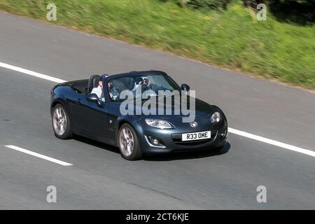 R33OME 2009 Mazda Mx-5 I Sport Tech Grey Car Roadster Petrol convertible cabriolet roof down driving on the M6 motorway near Preston in Lancashire, UK Stock Photo