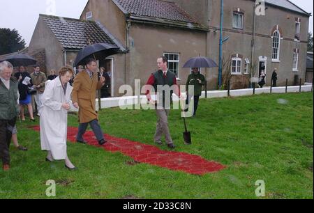 The Prince of Wales walks along the red carpet, as he visits South Airmyn Grange farm at Goole in East Yorkshire where he viewed cattle and planted an apple tree. The carpet was laid so the Prince, who is on a two-day tour in Yorkshire and North Lincolnshire, could walk from the house where he had been meeting Young Farmers to the orchard to plant the tree. Stock Photo