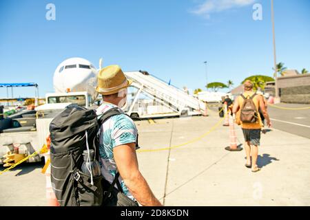 A Young traveling man get in the plane with passport on the landing strip Stock Photo