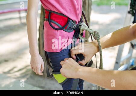 Child girl prepare for a bungee jump, put on safety belts Stock Photo