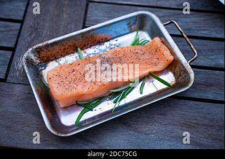 salmon fillet on a bed of rosemary twigs seasoned with salt and pepper Stock Photo