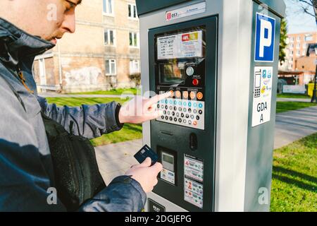 Man pays for parking with a credit card with NFS technology. Easy payment. Process of paying in machine parking terminal. Paymen Stock Photo