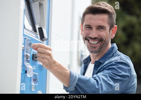 man paying for car parking at machine Stock Photo