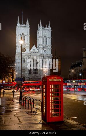 Westminster Abbey at night with red telephone box and London buses, London Stock Photo