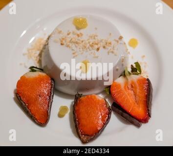 Fine dining dessert plate: coconut panna cotta, pineapple gel and chocolate dipped strawberries by chef Paul Wedgwood, Scotland, UK Stock Photo