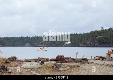 A sailboat sits at anchor in Bucaneer bay, of Thormanby Island on the coast of British-Columbia. A very popular anchorage for boaters and cruisers to Stock Photo