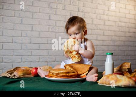 Little chef. Little kid dressed as a chef with pastries, buns, bread Stock Photo