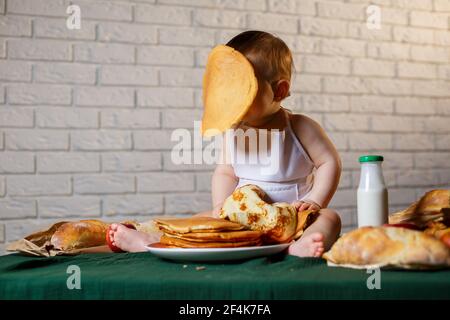 Little chef. Little kid dressed as a chef with pastries, buns, bread Stock Photo