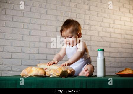 Little chef. Little kid dressed as a chef with pastries, buns, bread Stock Photo