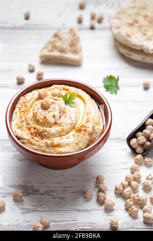 Bowl of homemade hummus on light background vertical format. Stock Photo