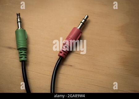 Colorful earphones cables connection on a wooden table Stock Photo