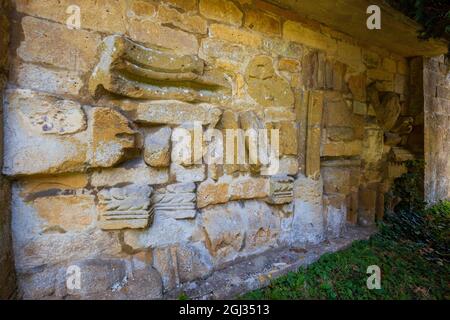 Fragments of the carved stonework from Hailes Abbey imbedded in the wall of St Peter’s church graveyard next to Stanway House, Cotswolds, England Stock Photo