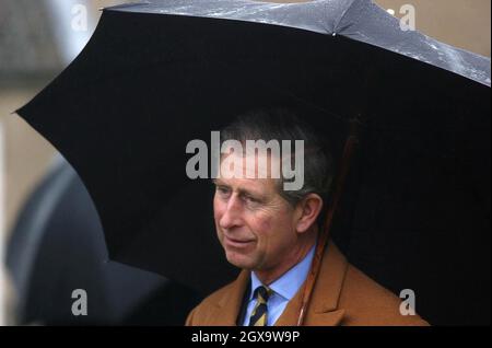 Prince of Wales shelters under an umbrella as he visits South Airmyn Grange farm at Goole in East Yorkshire where he viewed cattle and planted an apple tree. The Prince is on a two-day tour in Yorkshire and North Lincolnshire. Â©Anwar Hussein/allactiondigital.com  Stock Photo