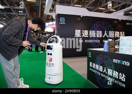 Macao. 2nd Dec, 2021. A staff member adjusts a robot on display at the first BEYOND International Technology Innovation Expo in south China's Macao, Dec. 2, 2021. Credit: Cheong Kam Ka/Xinhua/Alamy Live News Stock Photo