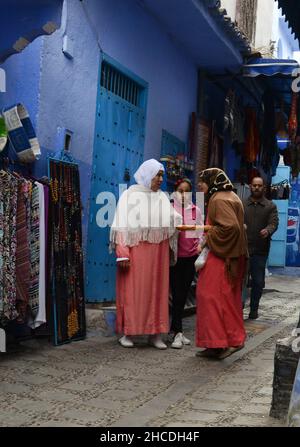 Local Moroccan women walking through the narrow streets of the medina of Chefchaouen, Morocco. Stock Photo