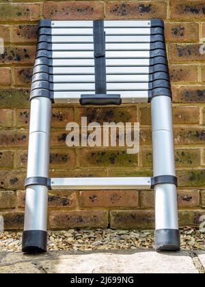 Aluminium tubular section telescopic access ladder collapsed down for storage Stock Photo