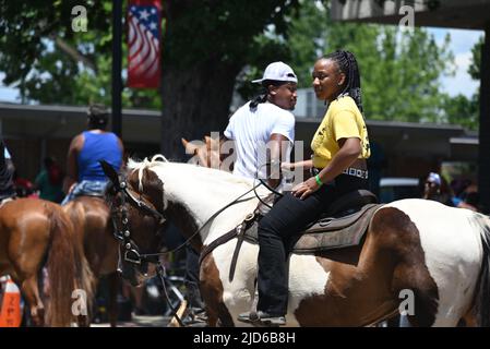 Zebulon, NC, USA, 18th June 2022, African American cowboys parade on horseback through downtown Zebulon as part of a weekend long Juneteenth celebration of emancipation from slavery. As of 2021, Juneteenth is a federal holiday commemorating the June 19 1865 military announcement proclaiming freedom for enslaved people in Galveston, Texas. Many slaves in Texas were unaware of President Lincoln’s 1863 Emancipation Proclamation which freed them from slavery two years earlier and slaves in Galveston were the last to hear the news. Credit D Guest Smith / Alamy Live News Stock Photo