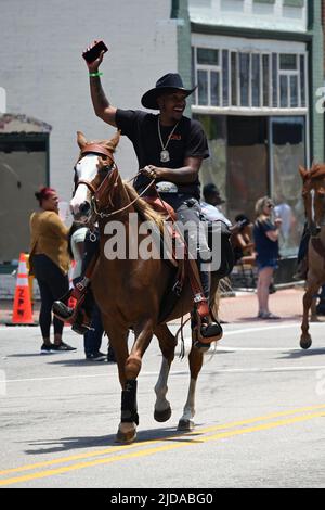 African American cowboys parade on horseback through Zebulon, NC, as part of a weekend long Juneteenth celebration of emancipation from slavery. Stock Photo