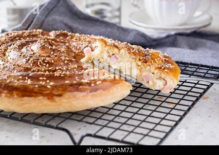 Homemade burek rolled pie with cheese, ham and sesame. Selective focus. Stock Photo