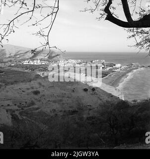 41. Spain. Photo journal is available at B.M.A. + Photo albums. Acquisition: Books and archive materials. Photos taken 1959-11-12.12 Pictures in series. According to notes: Spain. S. Mediterranean coast, Castell de Ferro, 12/11-59. View of Castell de Ferro from V.Tajen is taken from a mountain, down to a community. The community is located on a beach. Stock Photo