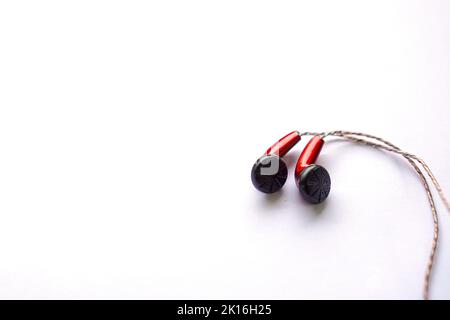 red earphones using wires isolated on white background. Stock Photo