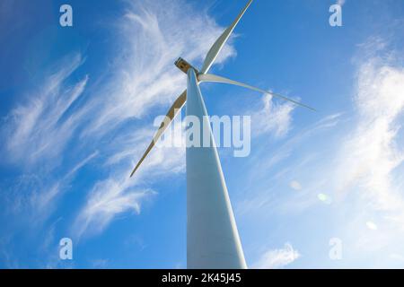 Renewable energy wind turbines isolated on the beautiful blue sky view from below Stock Photo