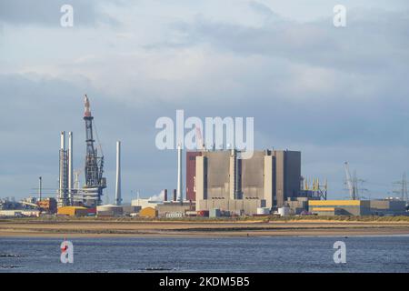 Crane at the Able recycling facility adjacent to Hartlepool Nuclear Power Station loading large wind farm turbine blades on to an installation vessel Stock Photo