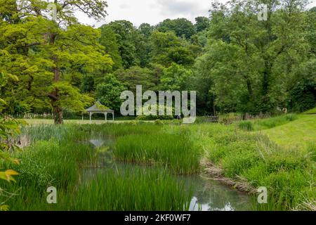 view of beautiful metal bandstand decorated with flowers set in a pretty English country garden Stock Photo