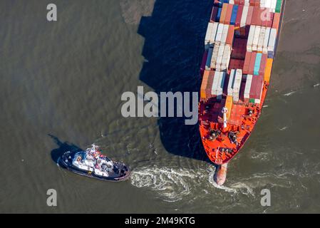 Aerial view of a tugboat pulling a container ship on the Elbe and giving direction, container, ship, Hamburg, Germany Stock Photo