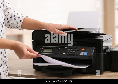 Employee using modern printer in office, closeup Stock Photo