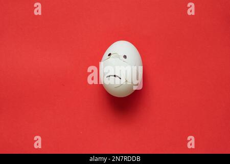 broken sad white chicken egg on a red Stock Photo