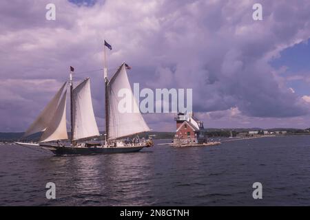 Schooner Stephen Tebo crossing in front of the Rockland, Maine breakwater lighthouse Stock Photo