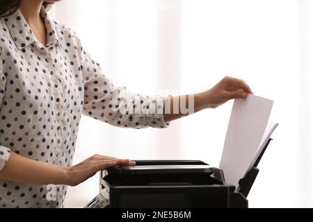 Employee using modern printer in office, closeup Stock Photo