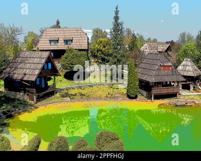 Stanisici, Bijelina, Bosnia and Herzegovina. April 25, 2021 Ethno-village, traditional village houses made of logs, Bosnian style of construction in the highlands. Lake with water.Wooden architecture. Stock Photo