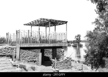 Douglas, South Africa - Mar 1, 2023: Angler at Samevloeiing near Douglas where the Orange and Vaal Rivers join. Monochrome Stock Photo