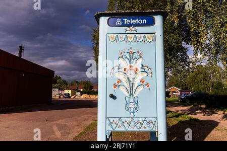 Production of Sweden's national symbol, the Dalahästen, Nusnäs, Sweden. In the picture: An old telephone booth outside the factory. Stock Photo