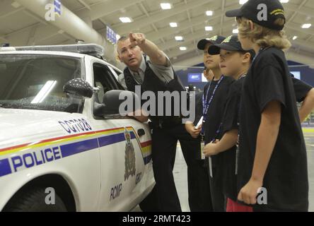 VANCOUVER (CANADA), Aug. 13, 2014 -- Children learn from police officers on how to handle a crime scene during the Junior Mountie Police Academy event in Coquitlam, Canada, Aug. 13, 2014. Dozens of students participate in the Junior Mountie Police Academy to learn about the knowledge of policing that organized by Royal Canadian Mounted Police (RCMP). During the 4-day camp, the children are participating in training and experiencing different policing scenarios.) CANADA-VANCOUVER-STUDENTS-JUNIOR MOUNTIE POLICE ACADEMY LiangxSen PUBLICATIONxNOTxINxCHN   Vancouver Canada Aug 13 2014 Children Lear Stock Photo