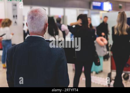 Meeting at the airport, person holding a placard card sign with welcome title text, greeting passenger on arrival, holding a name plate to greet trave Stock Photo