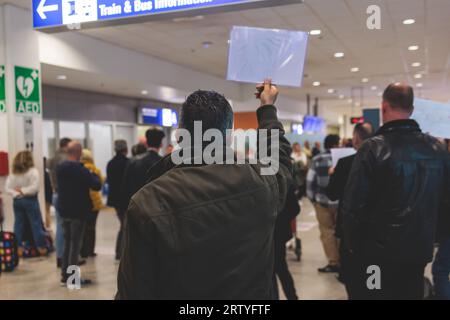 Meeting at the airport, person holding a placard card sign with welcome title text, greeting passenger on arrival, holding a name plate to greet trave Stock Photo