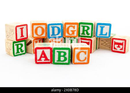 Multi-colored wooden letter blocks with ABC alphabets are selective focused isolated on white wood background Stock Photo