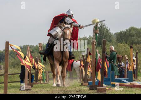 SAINT PETERSBURG, RUSSIA - SEPTEMBER 14, 2024: A warrior in medieval Russian armor on horseback chops a head of cabbage Stock Photo