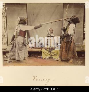 Fencing, about 1873-1883. Two men wearing protective gear fencing with long wooden poles.  A third man, also in protective gear, sits watching them. Stock Photo