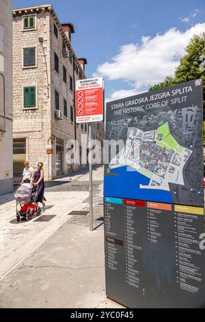 Split Croatia,Old Town,sign guide map points of interest attractions list,women mother residents,pushing baby carriage,walking pedestrians,sign notice Stock Photo