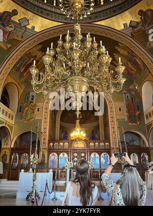 Santorini, South Aegean – GR – Oct 20, 2024 Tourists photograph the ornate interior of the Church of Ypapanti in Fira, Santorini, featuring golden cha Stock Photo