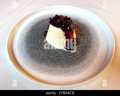 A traditional panna cotta dessert with a mixed berry sauce in a restaurant in Venice, Italy. Stock Photo