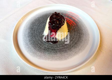 A traditional panna cotta dessert with a mixed berry sauce in a restaurant in Venice, Italy. Stock Photo