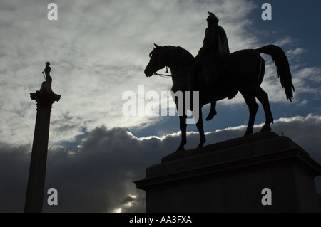 Statue of King George IV (4th) on horseback and Nelson's Column in silhouette Trafalgar Square London UK Stock Photo